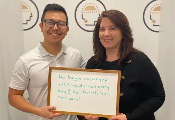 Chiropractor-Traverse-City-MI-Damian-Mendoza-with-Patients-Holding-Sign.webp